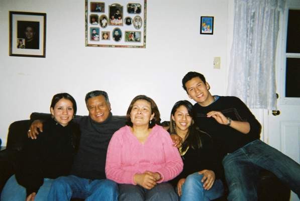 A photo of Habitat Partner Family Carlos, Eva and three of their children sitting on the couch in their old home in the year 2005.