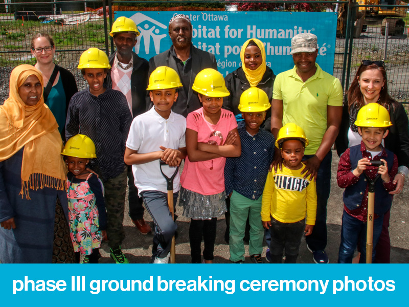 Group of Habitat Partner families and their children. Text at the bottom of image reads "phase III ground breaking ceremony photos".